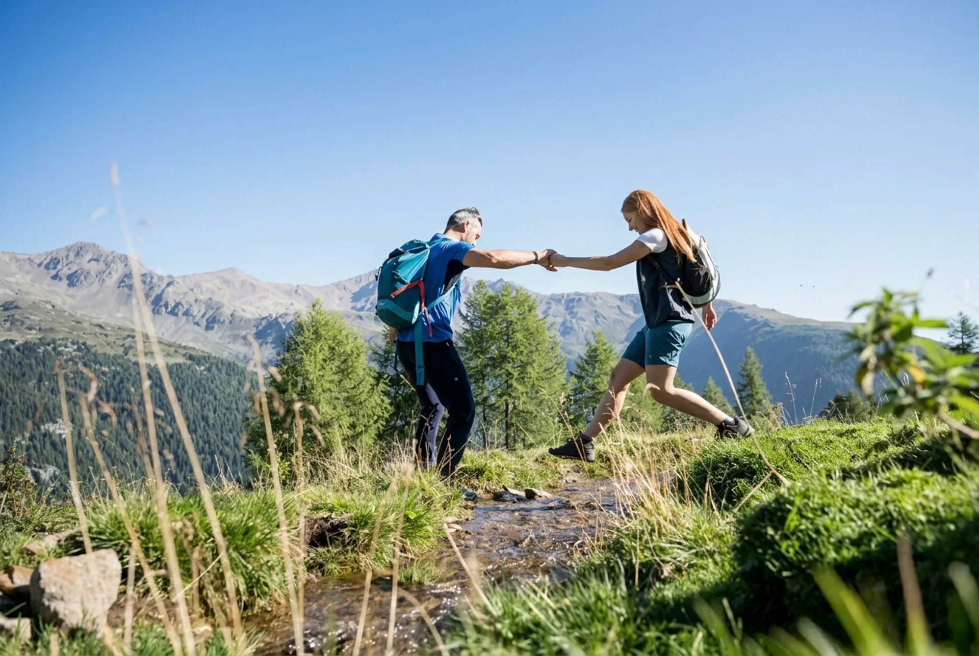 Wanderpaar überquert einen Bachlauf vor Südtiroler Bergpanorama
